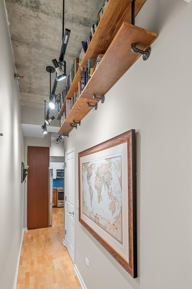hall with baseboards and light wood-type flooring
