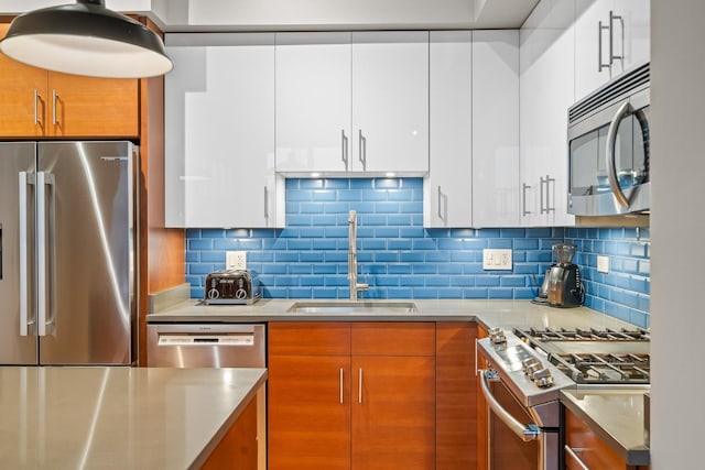 kitchen featuring a sink, appliances with stainless steel finishes, modern cabinets, and light countertops