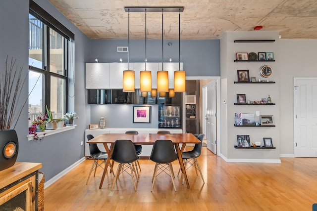 dining space with baseboards, visible vents, and light wood-style floors