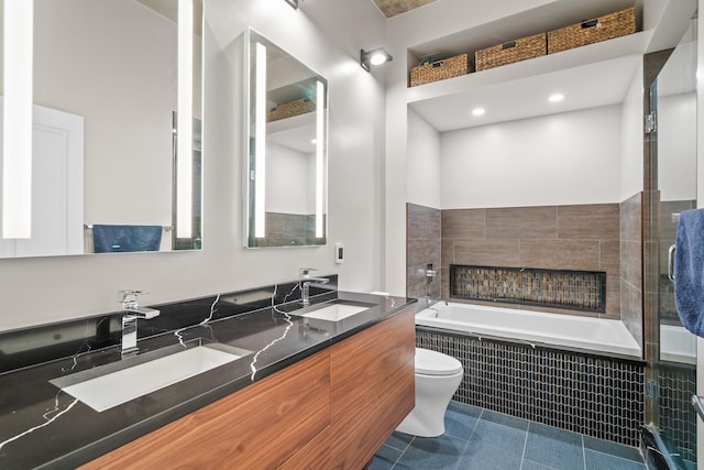 bathroom with tile patterned floors, a sink, a bath, and a tile fireplace