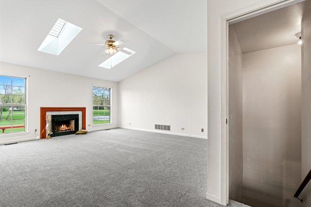 14 Mckinley Ln, Streamwood, IL 60107 - unfurnished living room with plenty of natural light, visible vents, a fireplace with flush hearth, carpet floors, and lofted ceiling with skylight