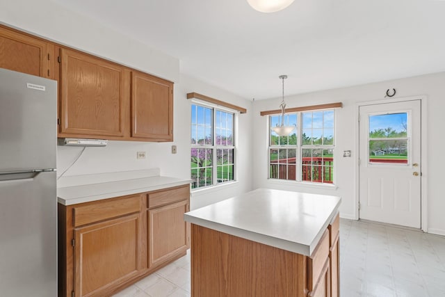 14 Mckinley Ln, Streamwood, IL 60107 - kitchen with freestanding refrigerator, light floors, a center island, light countertops, and hanging light fixtures
