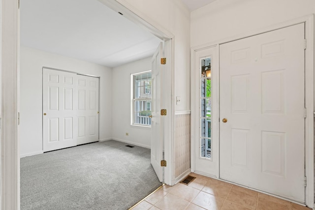 14 Mckinley Ln, Streamwood, IL 60107 - entryway featuring light tile patterned floors, baseboards, light colored carpet, and visible vents