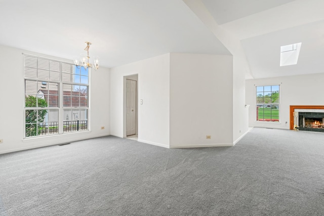 14 Mckinley Ln, Streamwood, IL 60107 - unfurnished living room featuring a skylight, baseboards, an inviting chandelier, and carpet flooring