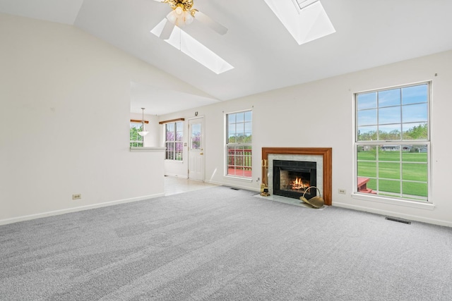 14 Mckinley Ln, Streamwood, IL 60107 - unfurnished living room featuring visible vents, carpet flooring, baseboards, lofted ceiling with skylight, and a fireplace with flush hearth
