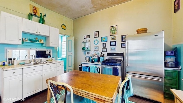 kitchen featuring white cabinets, appliances with stainless steel finishes, light countertops, and a sink