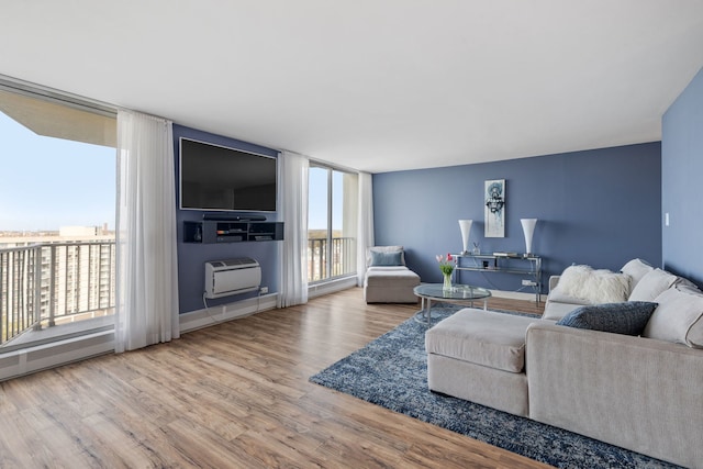 living room featuring a wall mounted air conditioner and wood finished floors