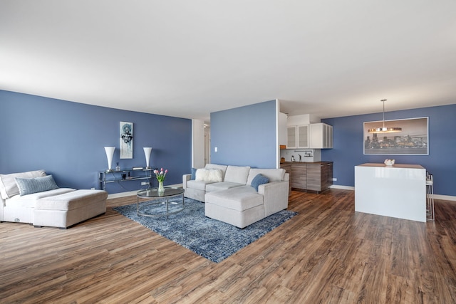 living area with baseboards and wood finished floors