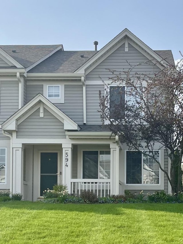 594 Blue Springs Dr, Fox Lake, IL 60020 - view of front of house with covered porch, a front yard, and roof with shingles