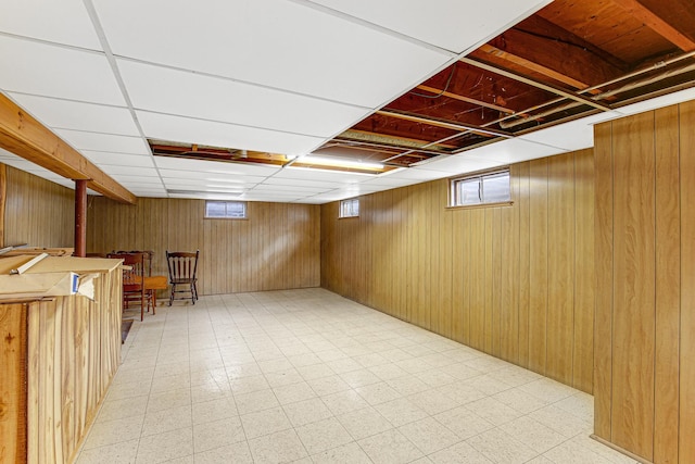 below grade area featuring wooden walls, plenty of natural light, and light floors