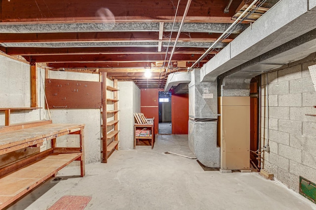 unfinished below grade area with heating unit and a workshop area