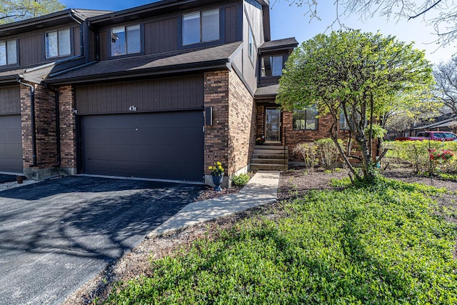 view of front of house featuring brick siding, a garage, and driveway