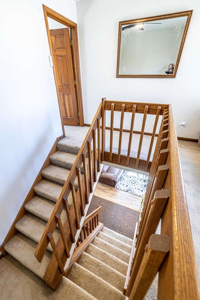 stairway featuring carpet floors and baseboards