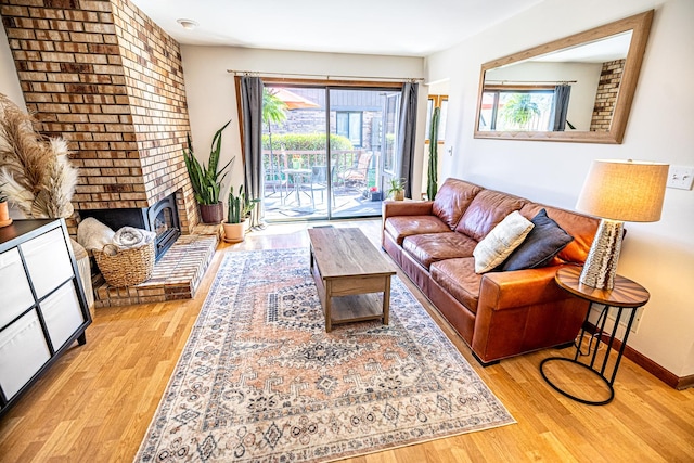 living room featuring baseboards, a fireplace, and light wood-type flooring