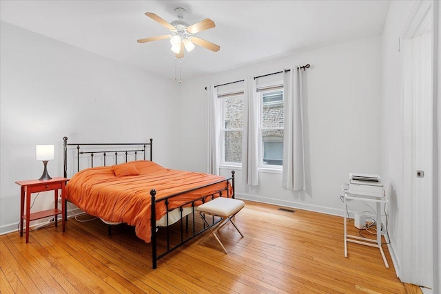 bedroom featuring baseboards, a ceiling fan, light wood-style flooring, and visible vents