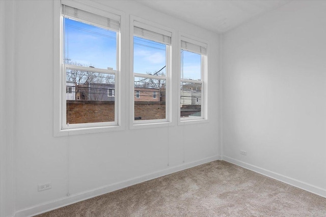 carpeted spare room featuring baseboards