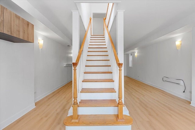 staircase with baseboards and wood finished floors