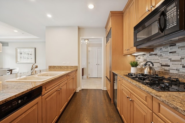 kitchen with visible vents, dark wood-type flooring, a sink, backsplash, and black appliances