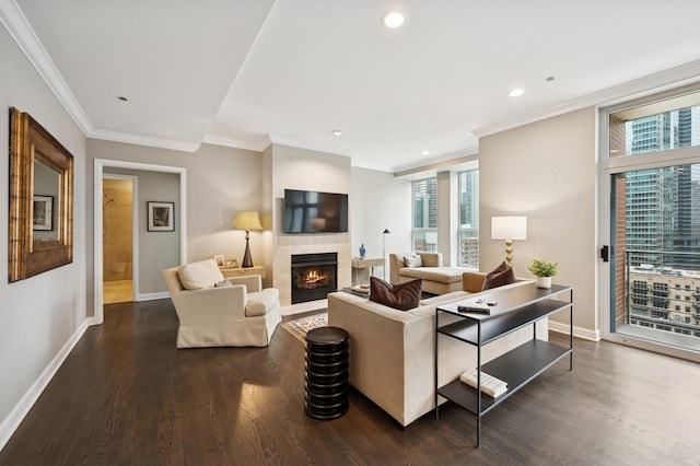 living area featuring a tiled fireplace, crown molding, baseboards, and dark wood-type flooring