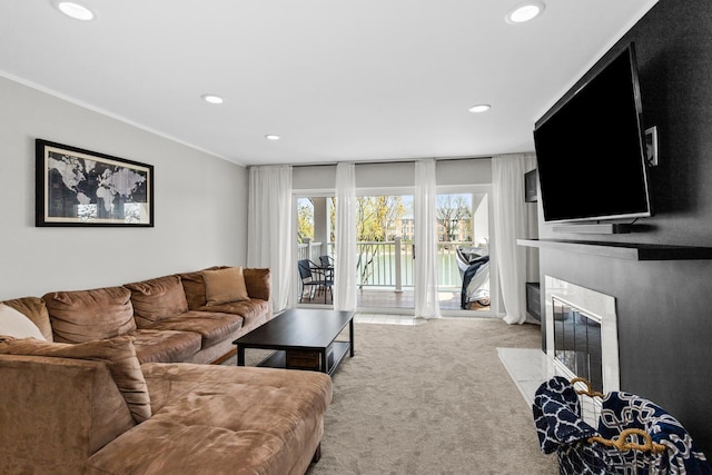 living room featuring a large fireplace, ornamental molding, carpet flooring, and recessed lighting