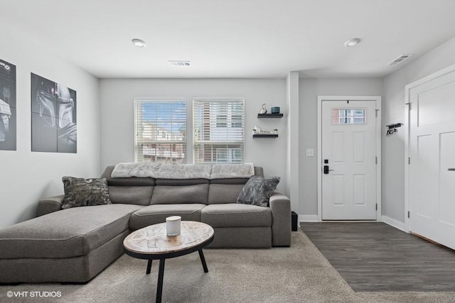 living area featuring baseboards, wood finished floors, and visible vents