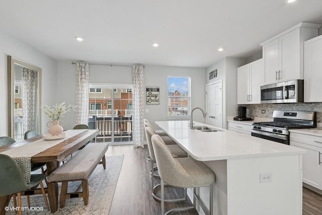 kitchen featuring an island with sink, a sink, appliances with stainless steel finishes, and recessed lighting