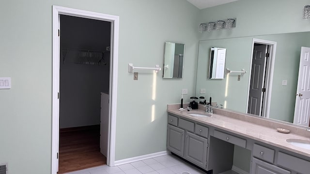 full bathroom featuring double vanity, a sink, and tile patterned floors