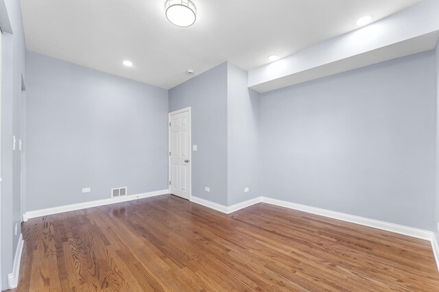 spare room featuring recessed lighting, visible vents, wood finished floors, and baseboards