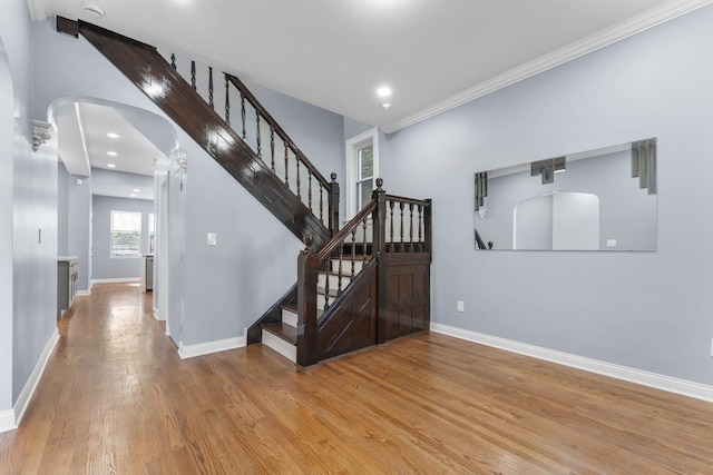 stairs featuring baseboards, recessed lighting, arched walkways, and wood finished floors