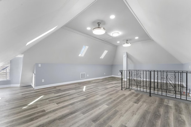 additional living space featuring baseboards, visible vents, and wood finished floors