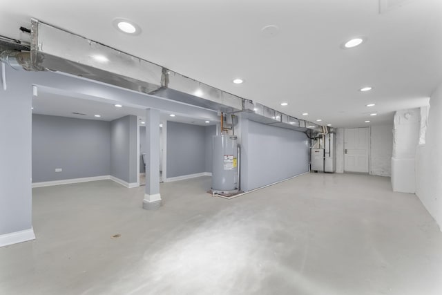 finished below grade area featuring baseboards, recessed lighting, gas water heater, and electric water heater