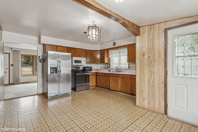 116 E Armitage Ave, Addison, IL 60101 - kitchen featuring appliances with stainless steel finishes, light countertops, a chandelier, a sink, and decorative backsplash