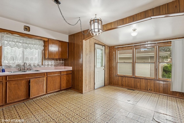 116 E Armitage Ave, Addison, IL 60101 - kitchen featuring a sink, brown cabinetry, wooden walls, light countertops, and a chandelier