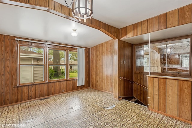 116 E Armitage Ave, Addison, IL 60101 - unfurnished dining area featuring wood walls, a chandelier, and baseboards