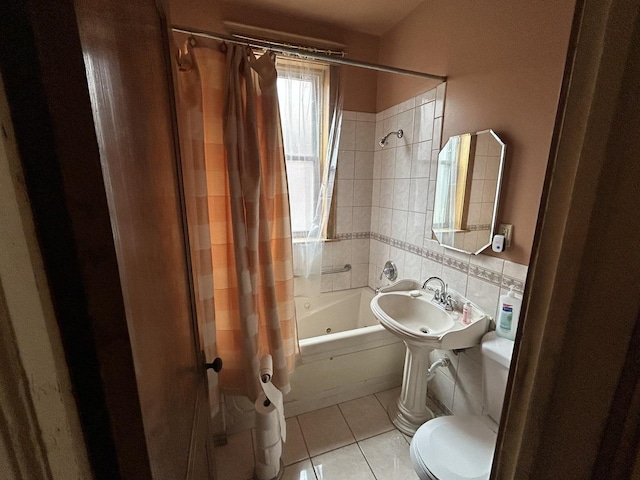 bathroom with tile patterned flooring, a sink, shower / bath combination with curtain, and toilet