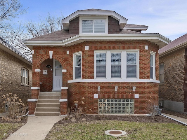 bungalow with roof with shingles and brick siding
