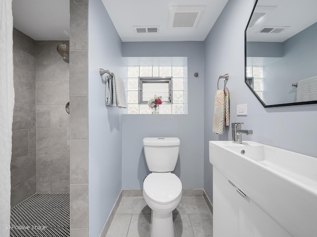 full bath with visible vents, a tile shower, and toilet
