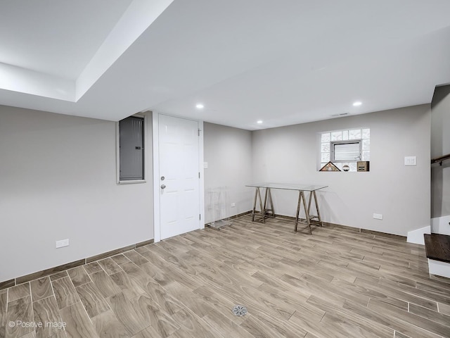 below grade area featuring light wood-style floors, recessed lighting, baseboards, and electric panel