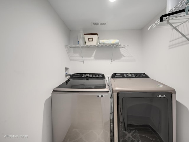 washroom with separate washer and dryer, laundry area, and visible vents