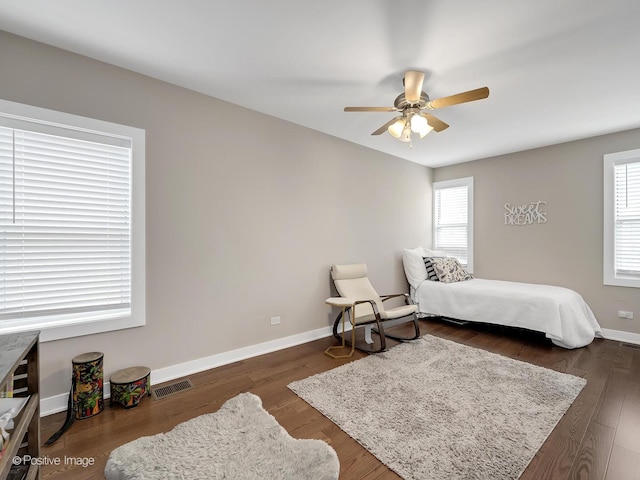 bedroom featuring visible vents, a ceiling fan, baseboards, and dark wood-type flooring