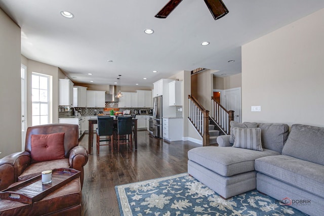 sitting room featuring baseboards, carpet flooring, recessed lighting, and an upstairs landing