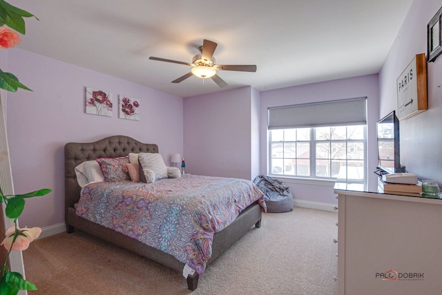 bedroom with light colored carpet, a ceiling fan, and baseboards