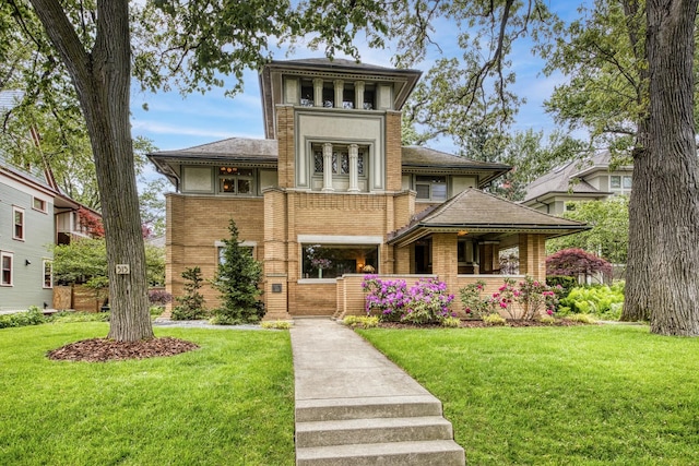 view of front of home featuring brick siding, a front yard, and covered porch