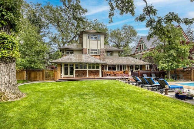 back of house featuring a wooden deck, a patio, and roof with shingles