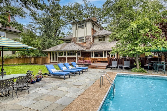 view of swimming pool with outdoor dining space, a wooden deck, and a patio
