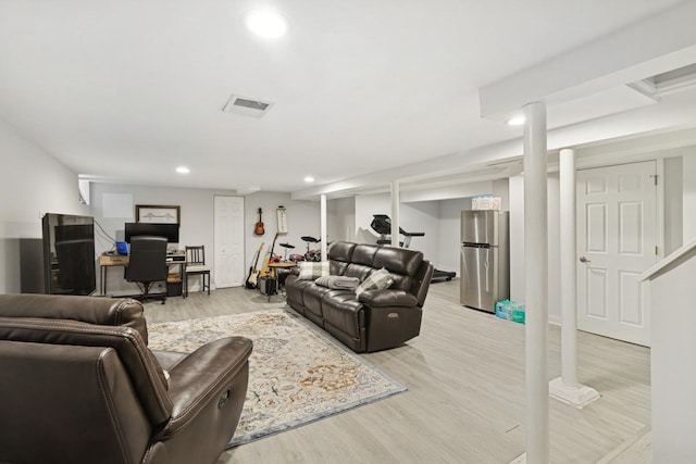 living room with recessed lighting, light wood-style flooring, and visible vents