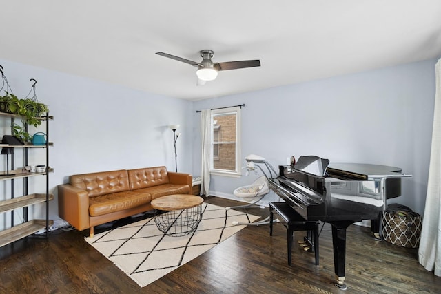 living area with baseboards, a ceiling fan, and wood finished floors