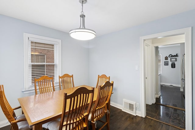 dining room with visible vents, baseboards, and wood finished floors