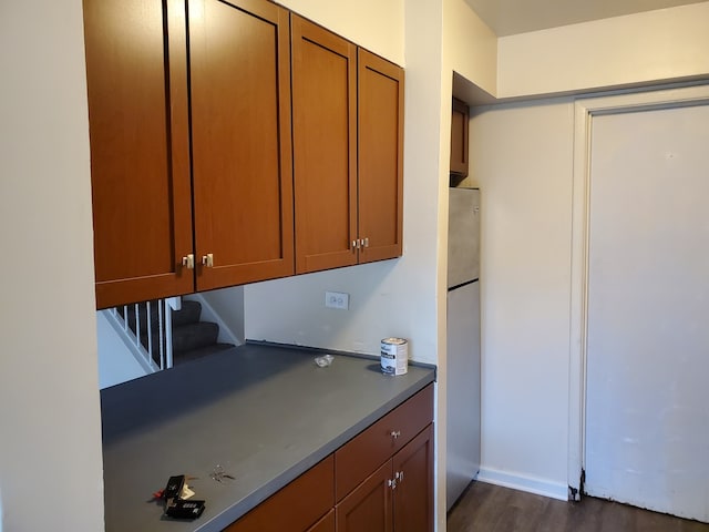 19135 Pine Dr Unit 2, Country Club Hills, IL 60478 - kitchen with freestanding refrigerator, dark wood-style flooring, brown cabinets, and dark countertops