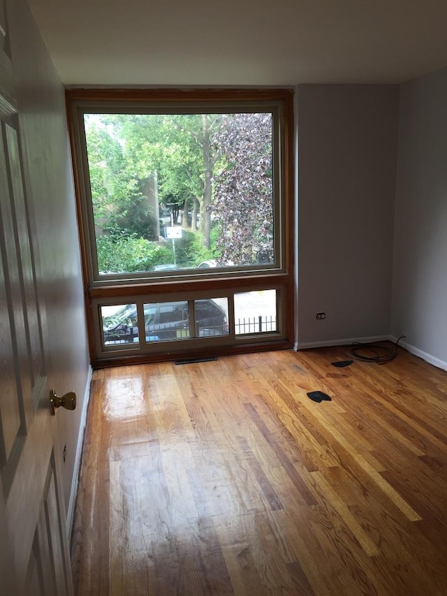 1428 E 55th St, Chicago, IL 60615 - spare room featuring baseboards and wood finished floors
